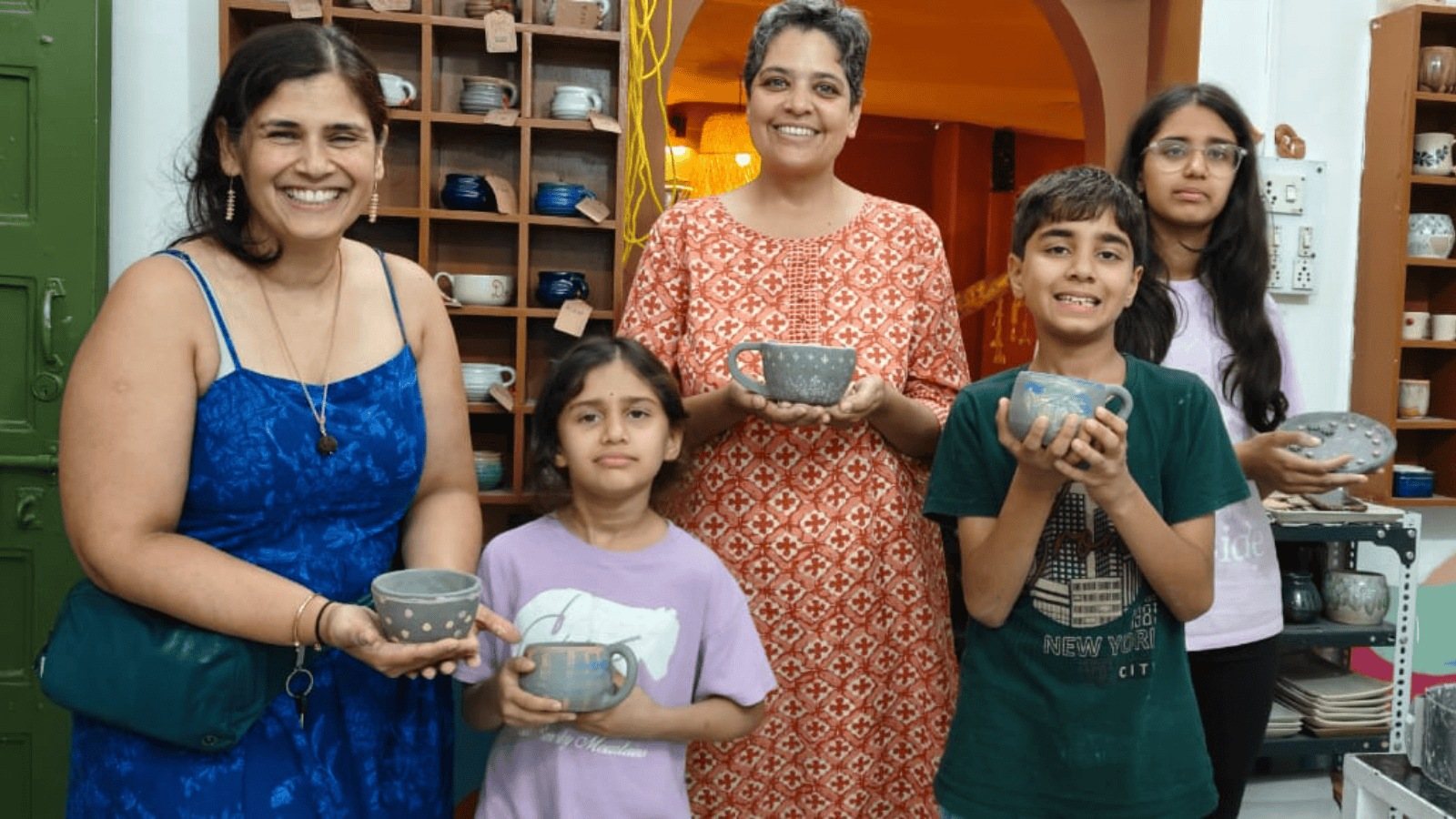 A family holding up the bowls they made