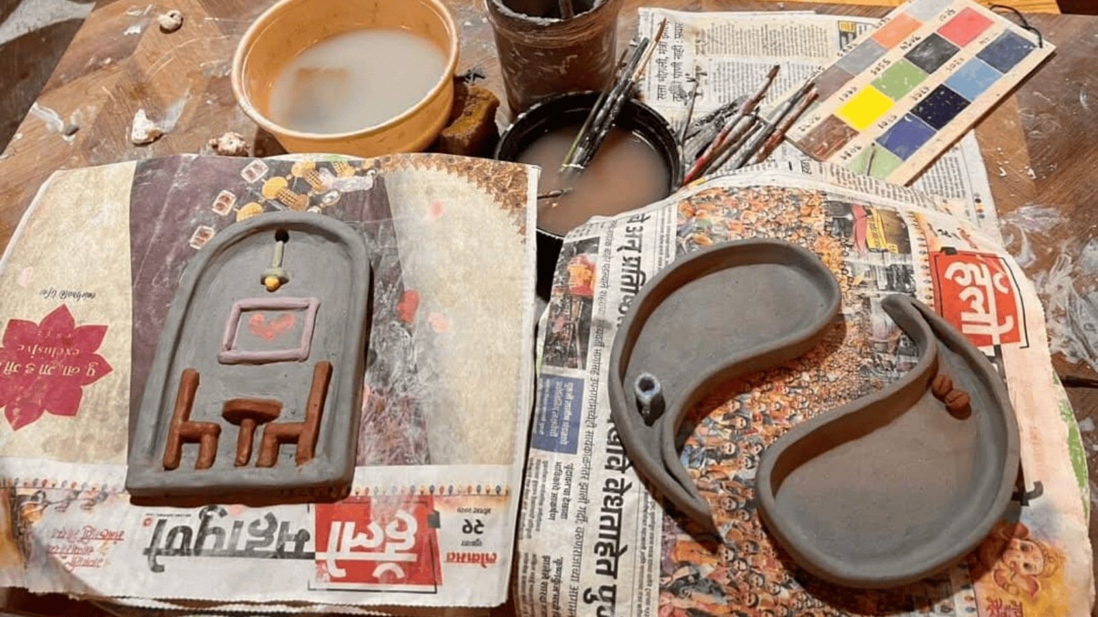 Clay pieces drying on newspaper