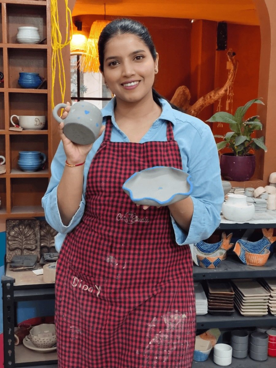 A guest proudly holding the bowl she made